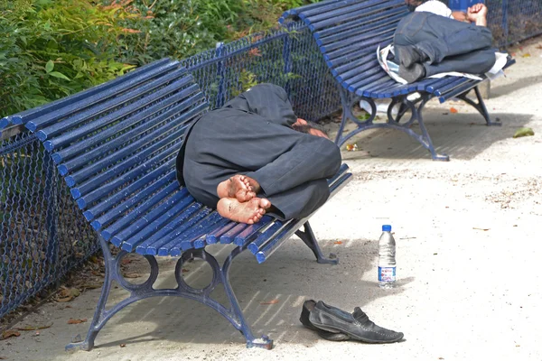 Senzatetto che dorme sulle panchine — Foto Stock