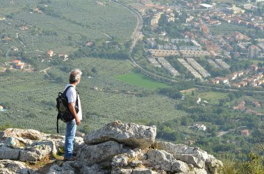 Man hiker looking over town clipart