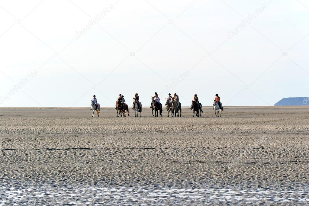 Riding horses on sand