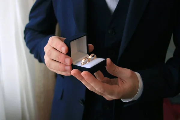 新郎の手の中の箱の中の結婚指輪 — ストック写真