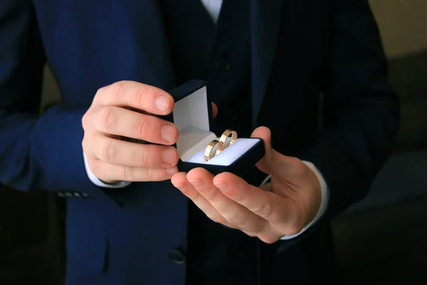 wedding rings in boxes in the hands of the groom