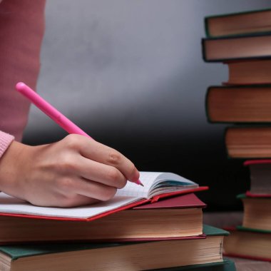 Liseli kız ödevlerini not defterine yazıyor, seçici odaklanma. 