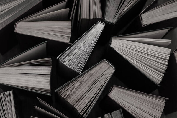 image of a stack of hardcover books, top view, monochrome books background, selective focus 