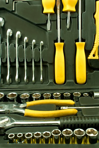 Набор различных хромированных желтых инструментов в коробке — стоковое фото