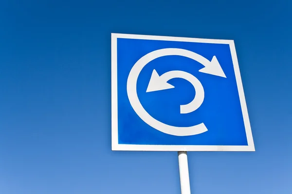 Roundabout sign over blue sky — Stock Photo, Image
