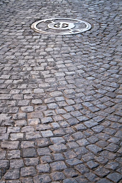 Cobble walkway with sewer cover — Stock Photo, Image