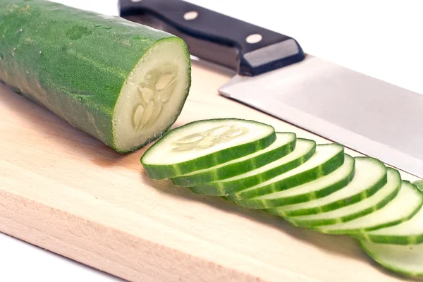 Cucumbers sliced on wooden board — Stock Photo, Image