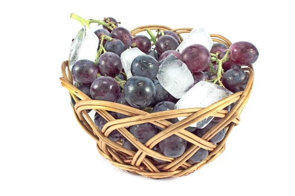 Uvas escuras em uma cesta com gelo isolado em branco — Fotografia de Stock