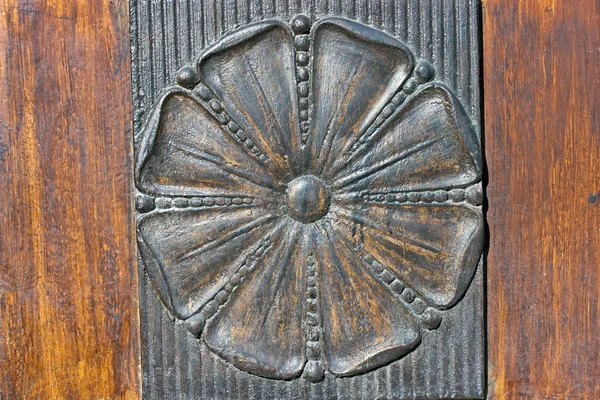 Fleur en relief de fer sculpté comme garniture sur la porte — Photo