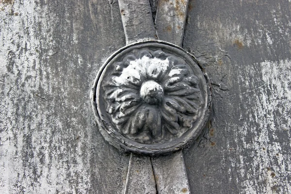 Flor de hierro forjado sobre una vieja cerca oxidada — Foto de Stock