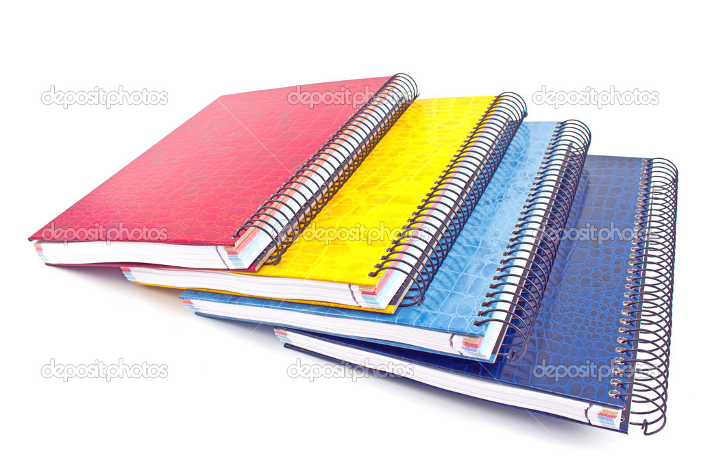 Stack of colorful spiral notebooks isolated on white