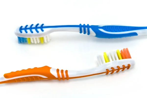 Beyaz zemin üzerine iki renkli diş fırçaları — Stok fotoğraf