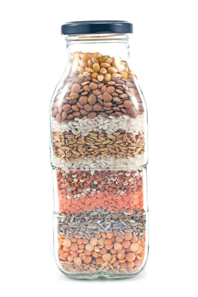 Decorative glass bottle with seeds isolated on white — Stock Photo, Image