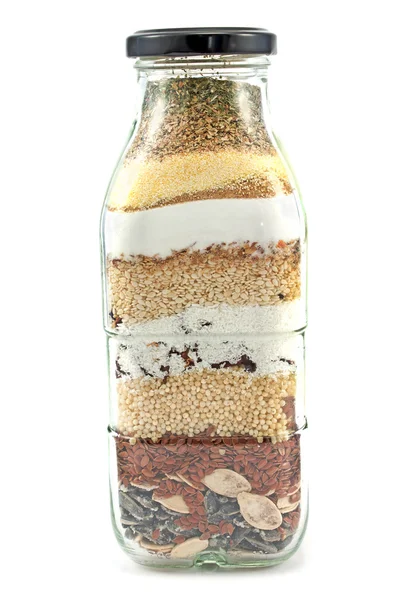 Decorative glass bottle with seeds isolated on white — Stock Photo, Image