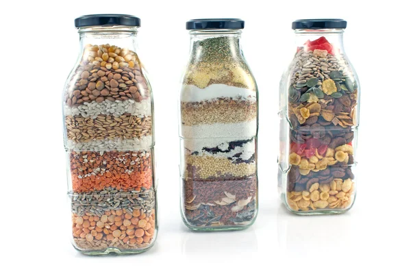 Garrafas de vidro decorativas com sementes isoladas em branco — Fotografia de Stock