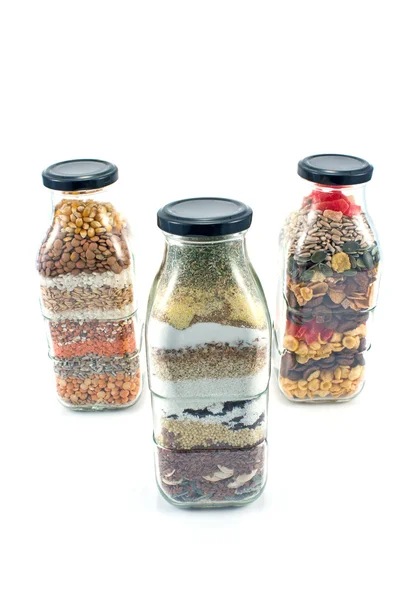 Decorative glass bottles with seeds isolated on white — Stock Photo, Image