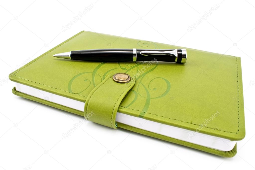 Pen and green notebook isolated on white