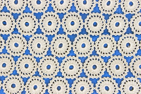 Handgemachte weiße Spitze auf blauem Hintergrund — Stockfoto