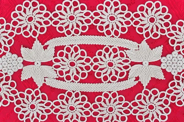 Handmade white lace on red background — Stock Photo, Image