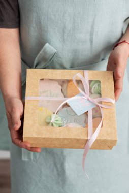 Paskalya hediyesi kutusunu kurabiyelerle tutan kadın, seçici görüntü odaklı