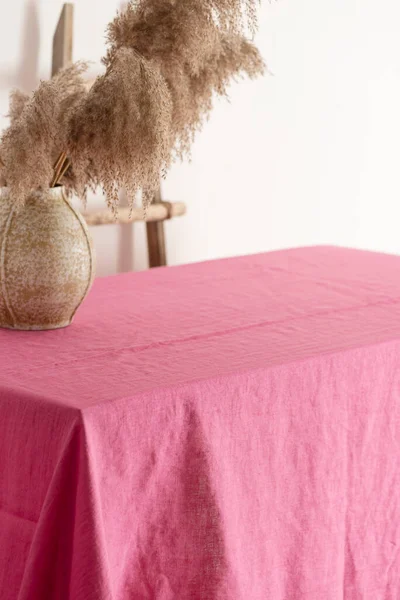 Home decor concept, table with pink tablecloth, selective focus image
