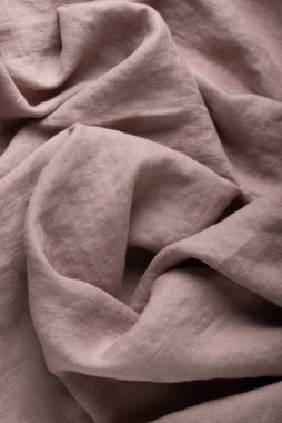 Stonewashed linen fabric in lilac color, sewing concept, selective focus image