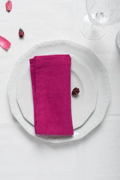 Concept of table decoration, Fuchsia linen napkin on the white dish, selective focus image
