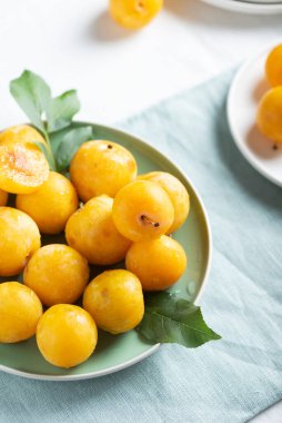 Yaz konsepti, masada taze sarı erikler, seçici odak görüntüsü.