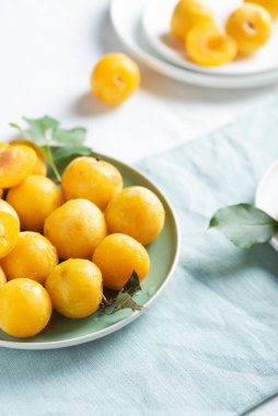 Yaz konsepti, masada taze sarı erikler, seçici odak görüntüsü.