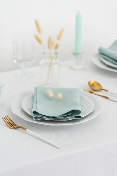 Table linens decoration with light green linen napkins and candle, selective focus image