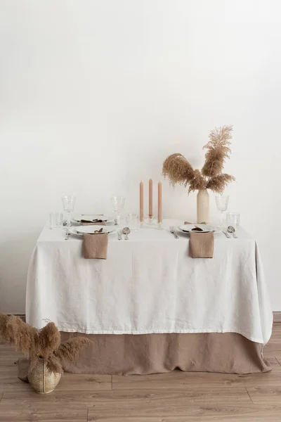 Concept of table decoration with linen white tablecloth and beige napkins, selective focus image
