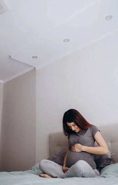 Atractiva Mujer Embarazada Está Sentada Cama Sosteniendo Vientre Últimos Meses — Foto de Stock