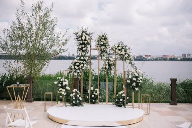 Güzel yuvarlak düğün kemer çiçek ve yeşillik yakınındaki göl veya nehir açık havada, kopya alanı süslenmiş. Açık Hava düğün töreni için dekorasyon