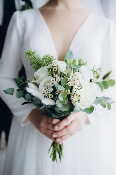 白いドレスに身を包んだ花嫁がシックな花束を手に 豪華な結婚式の花束 女の子は花を持っています アーケード — ストック写真