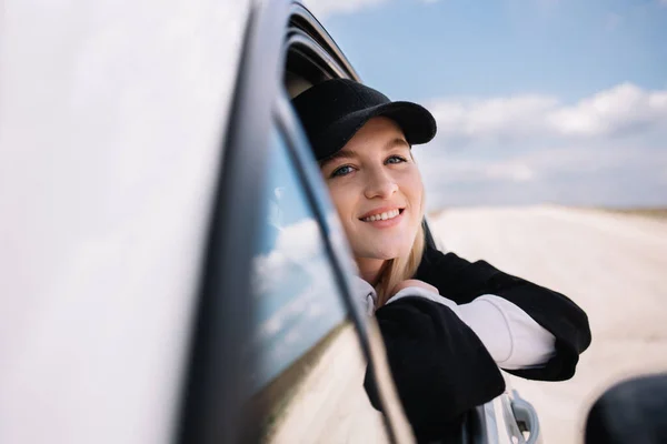 Piękna Dziewczyna Prowadzi Samochód Uśmiecha Się Lusterku Bocznym Samochodu — Zdjęcie stockowe