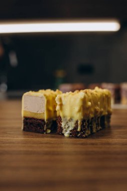 Mangodan yapılmış lezzetli kremalı çikolatalı pasta ve üstünde balonlar olan sarı renkli çarkıfelek meyvesi. Beyaz bir tabakta kesilmiş bir parça ve güzel katmanlar halinde kesilmiş.