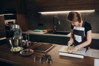 Pasta şefi, mutfak masasında mutfak kasesi olan beyaz bir kadın. Tatlı yapmak için.
