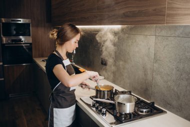 Güzel genç bayan ocakta şeker hazırlıyor.