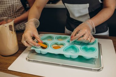 Şef pasta cupcake silikon kalıp koyu arka plan üzerinde içine hamur doldurarak bir siyah önlük. Şekerleme yemek kavramı