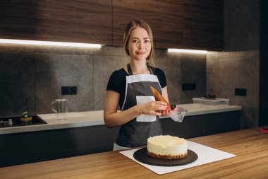 İş yerinde şekerleştirici. Krem kek dekorasyon. Pişirme tablosu gri bir arka planda bir pasta hazırlamak.