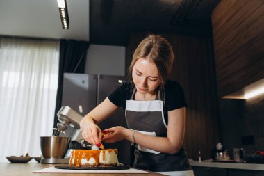 Şekerci modern bir mutfağa karamel keki döker.