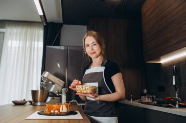Mutfakta şekerlemeci. Üniformalı kadın. Profesyonel pastayı süslüyor..