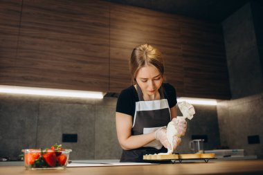 Pasta şefi pastayı böğürtlenlerle süslüyor.