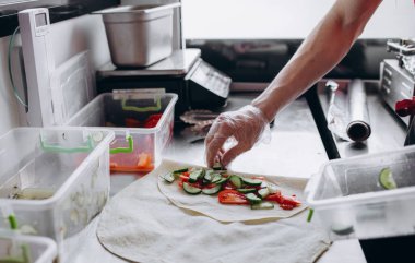 Tavuk ve sebze ile geleneksel shawarma şal sarma Erkek elleri