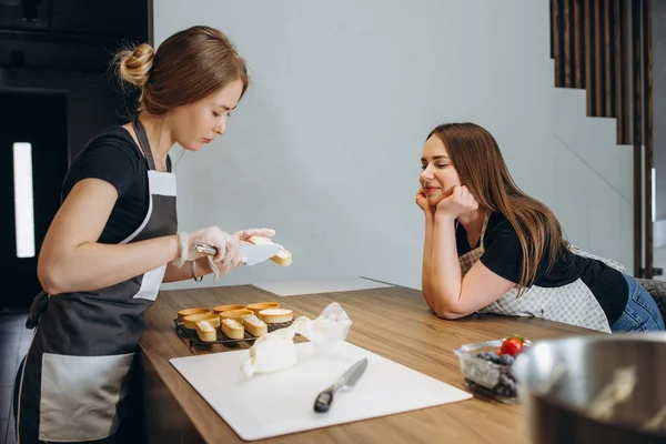 Две Красивые Девушки Готовят Сладкие Торты Кухне Дома — стоковое фото
