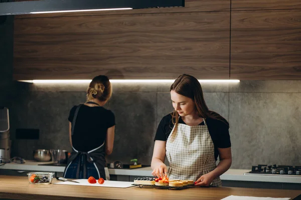 latin woman pastry chef wearing uniform holding a bowl preparing delicious sweets chocolates at kitchen in Mexico Latin America