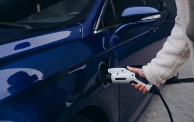 İnsan eli elektrik araba şarj elektrikli araba bağlamak tutuyor
