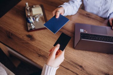 Seyahat acentesinde seyahat eden bir seyahat acentasındaki genç çift kredi kartı ödemelerini yakın planda yapıyor.