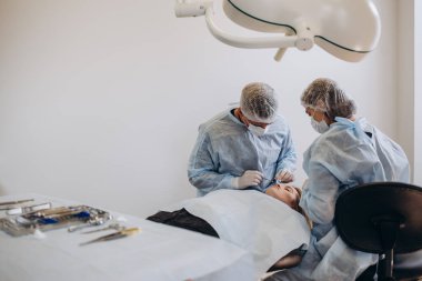 Göğüs Hastanesi ameliyathane kozmetik ameliyat cerrah. Cerrah cerrahi büyüteçler tıbbi prosedür sırasında giyen maskeli. Göğüs büyütme, genişleme, geliştirme