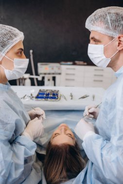 Ameliyat ameliyatı. Ameliyathanede ameliyat ekipmanlarıyla bir grup cerrah. Tıbbi geçmiş, seçici odaklanma. Ameliyat sırasında cerrah ekibi birlikte çalışıyor.